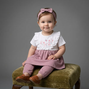A Baby model of Palm and pale is offered a Baby girl frock with pajama and hairband for newborn to 2 years baby girl with deep pink color and floal print on front side in summer cotton fabric.