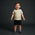 Toddler boy wearing a Palm and Pale cream short-sleeve t-shirt with shoulder snaps and black cotton shorts, available in sizes 0 to 24 months.