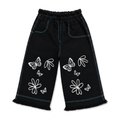 Girls' black wide leg denim pants with white butterfly and floral outline print, teal contrast stitching, elastic waist, and frayed hem — front view