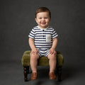A baby boy model is weared a palm and pale stripe white and blue romper to repesent the premium quality of coton fabric for summer weather for newborn baby to 24 months baby boy.