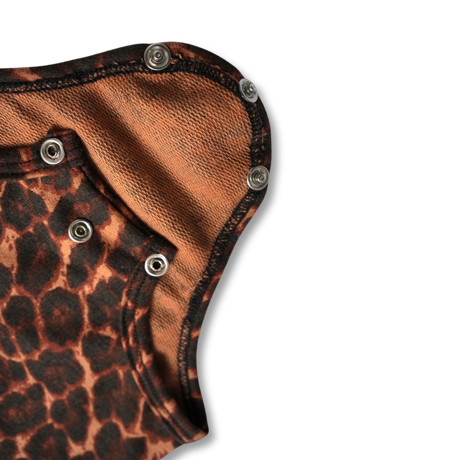 Detail shot of a brown and black leopard print baby bodysuit with snap fasteners at the crotch
