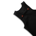 Close-up of the shoulder strap and dark wooden buttons on black baby overalls