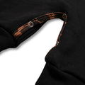 Close-up of the shoulder strap and dark wooden buttons on black baby overalls