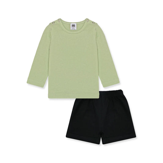 Newborn baby outfit featuring a long-sleeve green shirt with snap buttons on the shoulders and black short boxer. The design is simple and breathable, perfect for little smiles. Background includes playful elements and text highlights like 'New Arrivals' and 'Sunny styles for little smiles.' Brand logo and website 'palmandpale.com' are included.